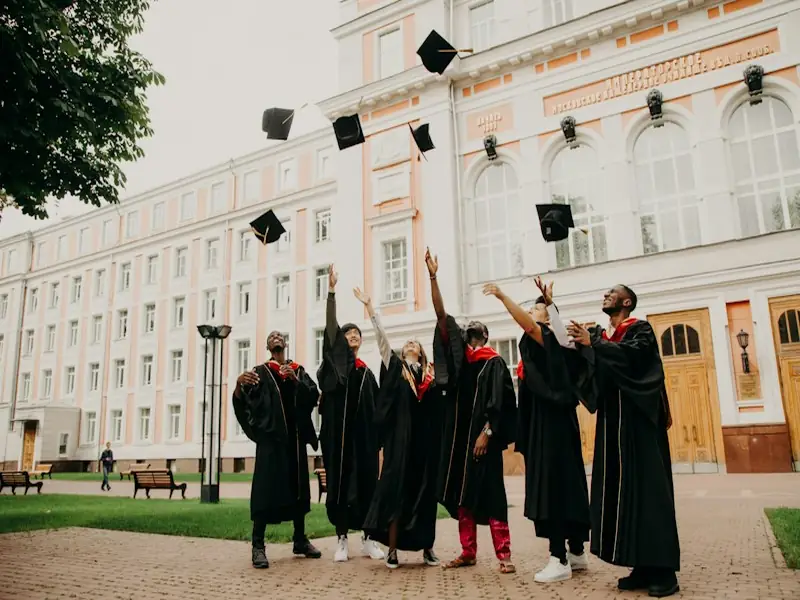 Graduates in gowns tossing their caps in the air